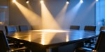 Spotlights from different directions converge on the centre of an empty boardroom table, symbolizing diverse perspectives creating collective wisdom.